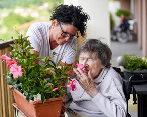 older person smelling flowers