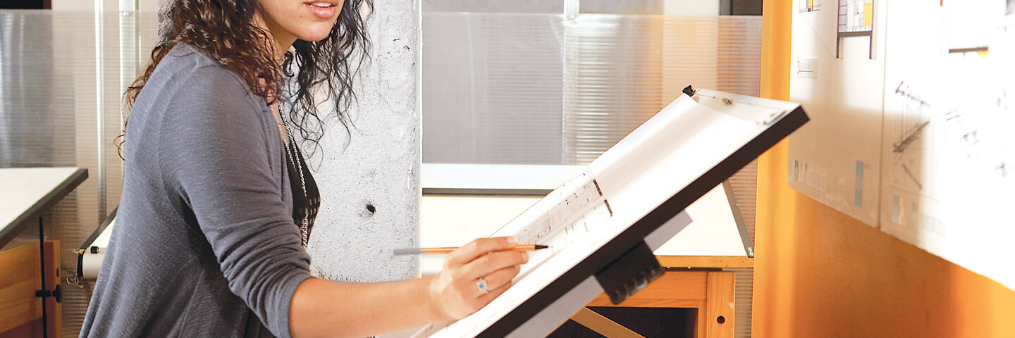 Female architect student working on design plan.