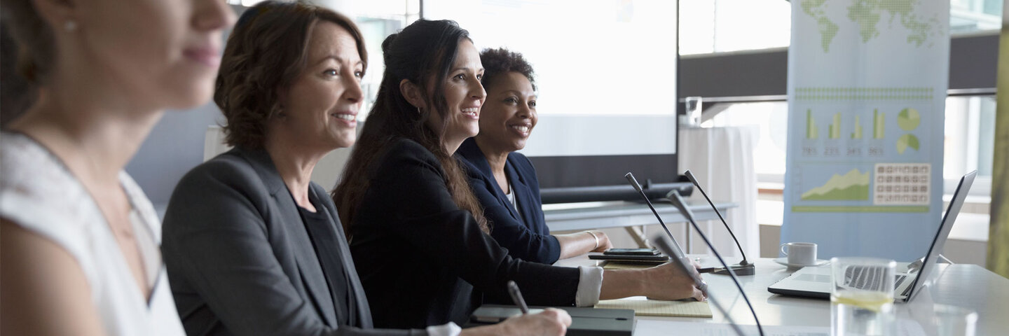 Speakers sitting on a panel at a conference