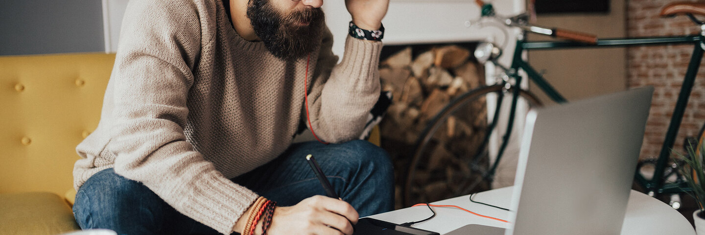 Student working on his tablet and laptop