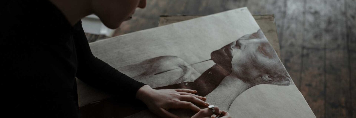 Woman sketching a charcoal portrait in art studio