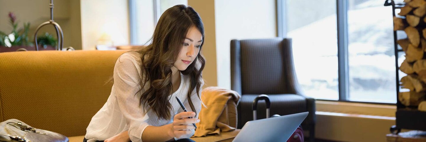 Businesswoman working at laptop in lobby
