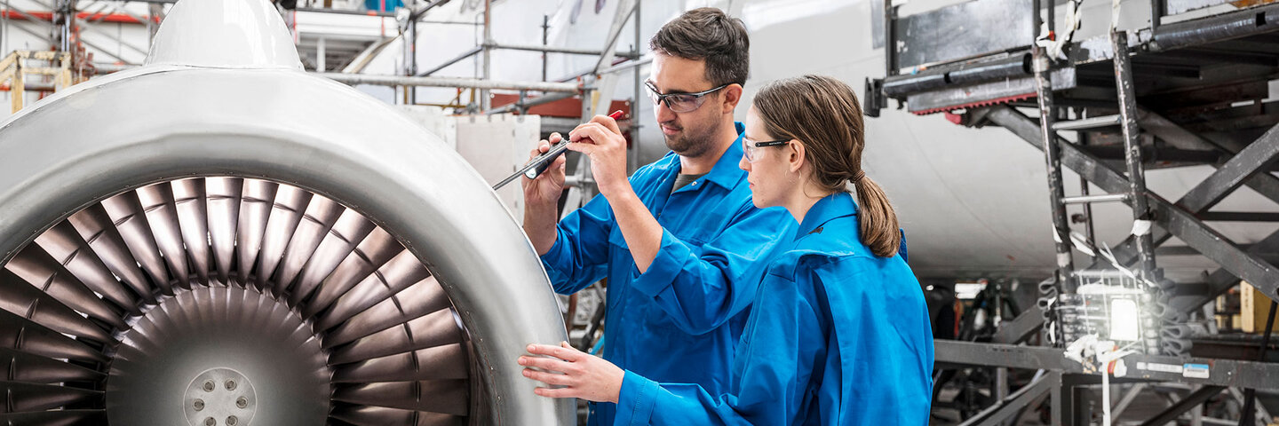 Workers using traditional tools manufacturing aircraft