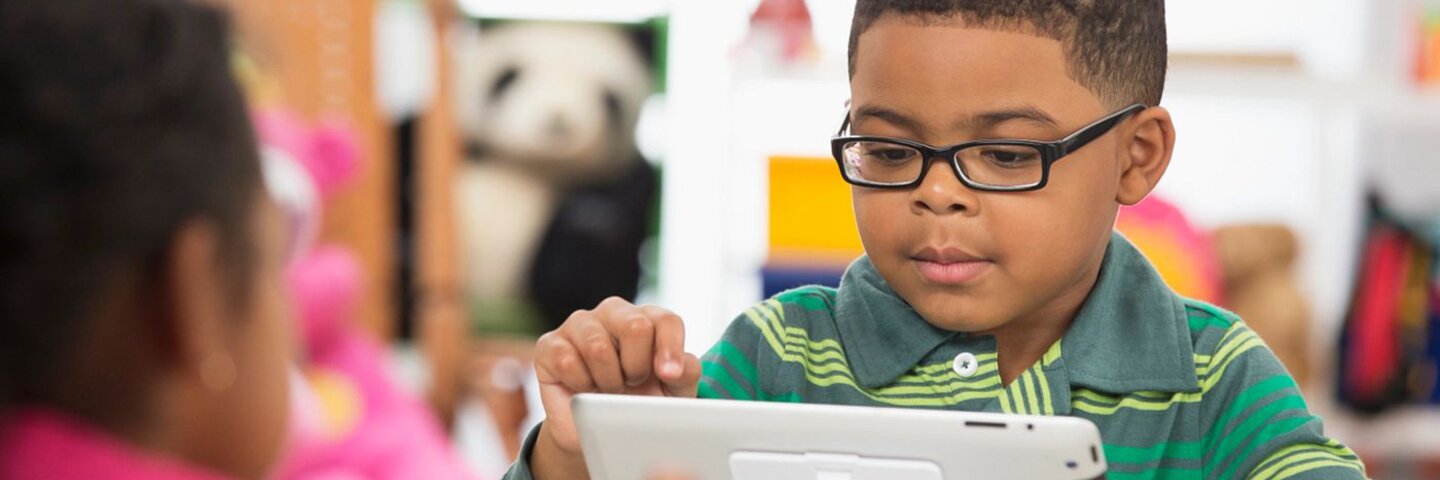 Students using digital tablet in classroom