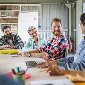 smiling writers sitting around a table