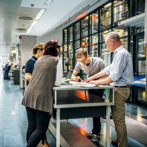 Professionals collaborating around a table, representing teamwork and leadership
