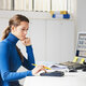 female accountant in blue sweater using calculator