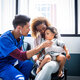 male nurse listening to a young patients heart beat